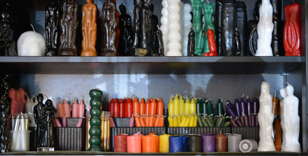 A store shelf at the Green Man Store with multiple types of candles on display