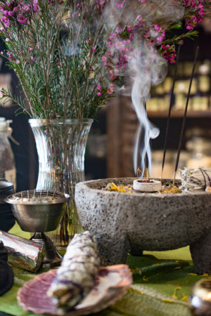 Smoke rises from a stone bowl containing incense