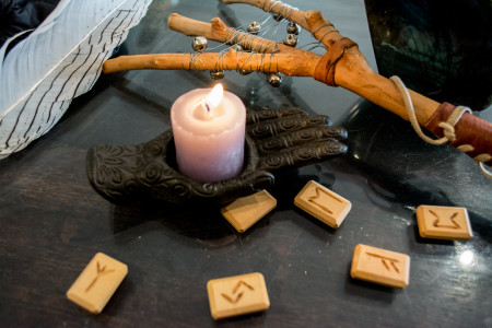 Rune tiles arranged on a table with a candle