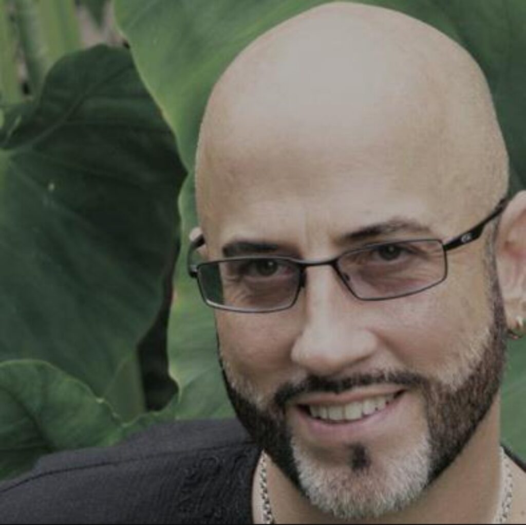 a man with glasses smiling