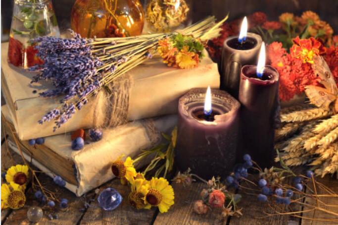 a stack of books and candles with flowers
