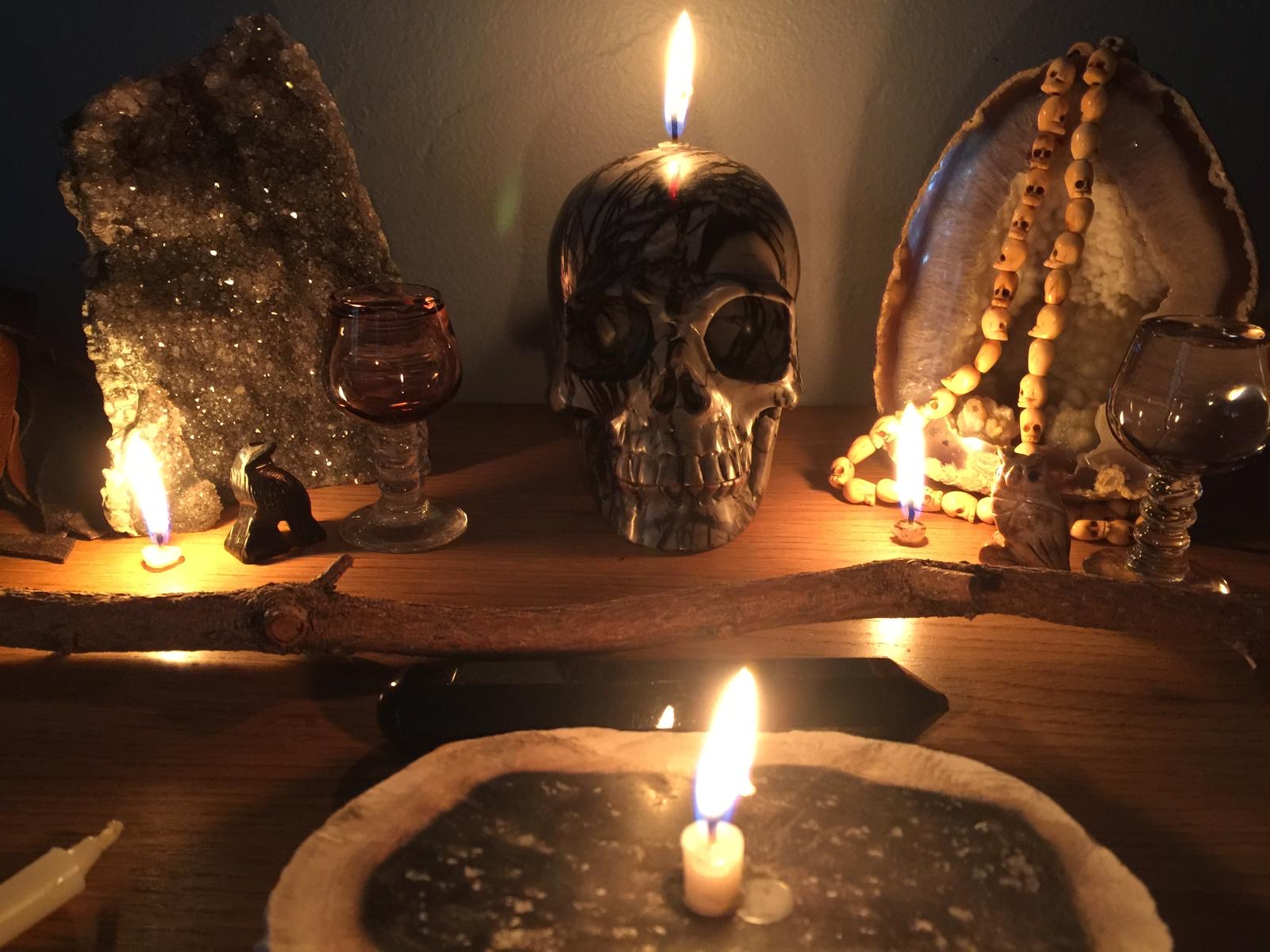 A skull candle and a candle holder with candles and a plate with an elephant