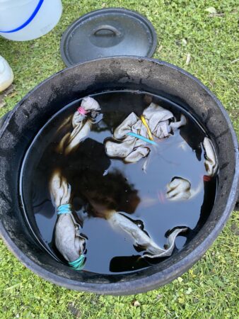 A black bucket with water and clothes in it